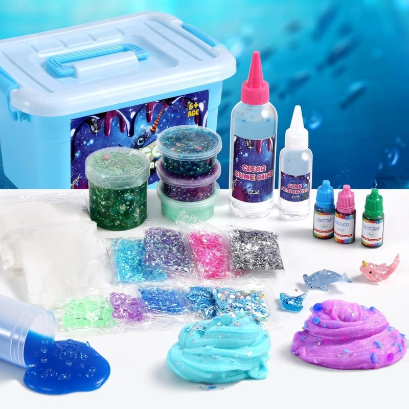 Set de regalo del kit de slime de bricolaje con temática de galaxia exhibido con caja de almacenamiento azul, pegamento transparente, activador, pigmentos, sobres de purpurina y slimes terminados.