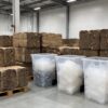 Baled cardboard and separated plastic film recycling bins in a warehouse sorting area